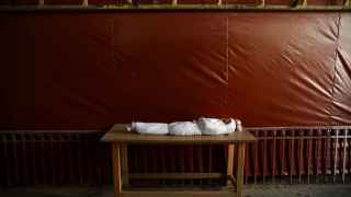 El cuerpo de un niño, envuelto en mortajas, a la espera del funeral.