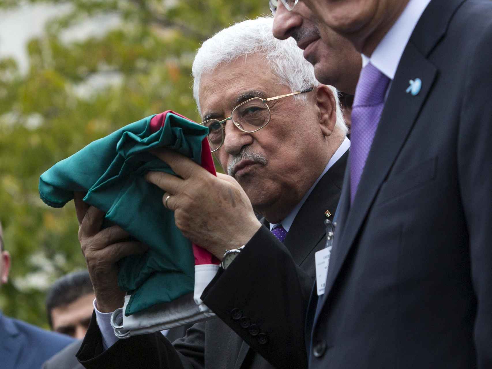 El presidente de la Autoridad Nacional Palestina, Mahmud Abbas, sostiene una bandera palestina en el cuartel general de la ONU.