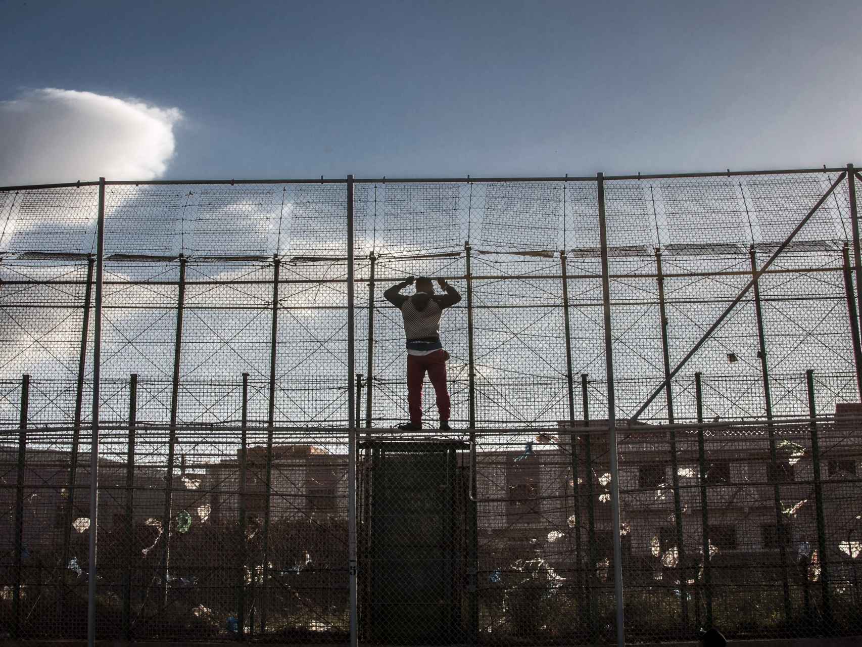 Un migrante africano en la valla de Melilla