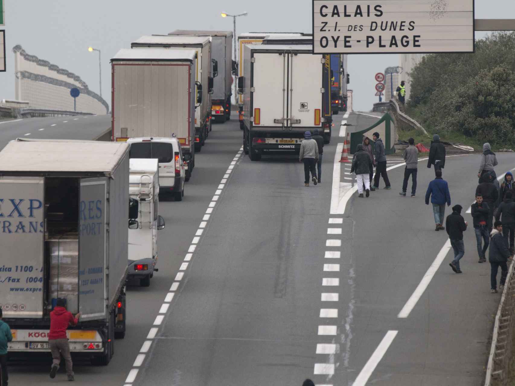 Inmigrantes intentan subirse  a los camiones en Calais