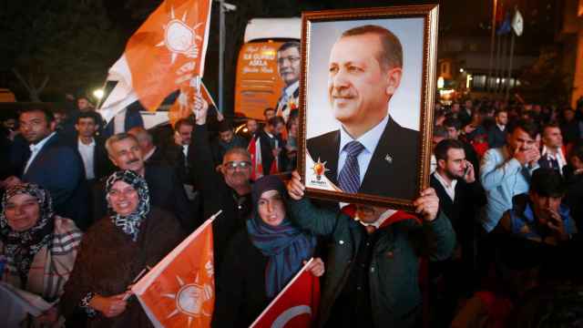 Votantes turcos sujetan el retrato del presidente turco Tayyip Erdogan.