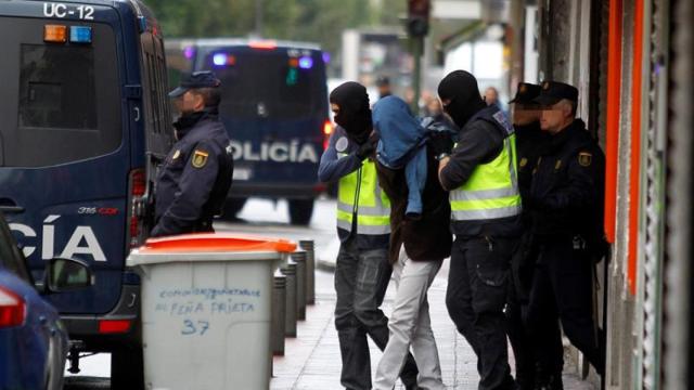 Uno de los detenidos en Madrid sube a un furgón policial.