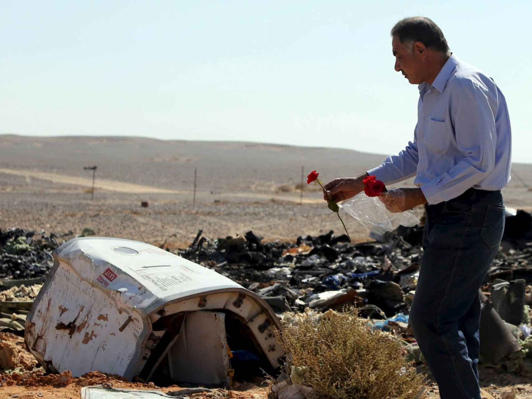 Un hombre deposita una flor junto a los restos de la aeronave.