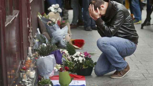 Un hombre deposita flores en Le Carillon, el restaurante atacado.