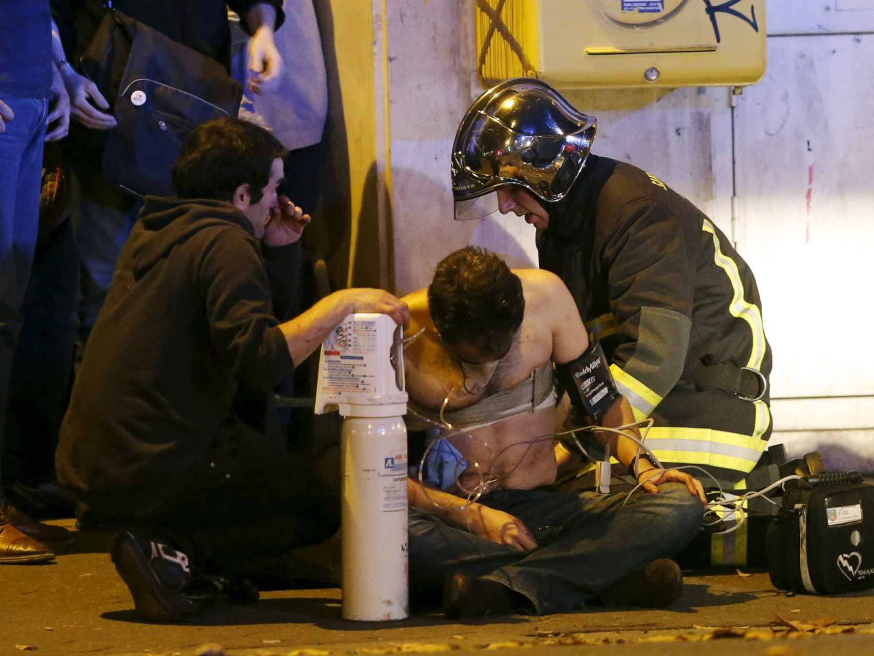 Los bomberos atienden a uno de los heridos. / Reuters