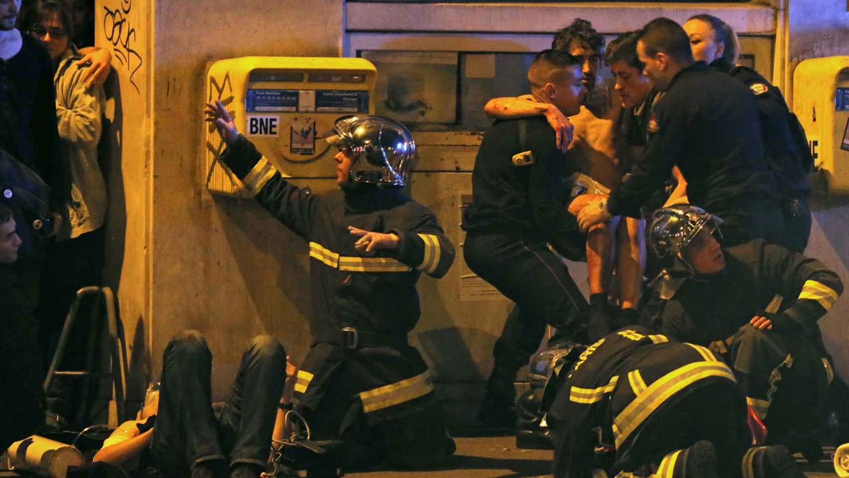 Los bomberos asisten a un herido cerca de la sala Bataclan. Foto: Christian Hartmann / Reuters