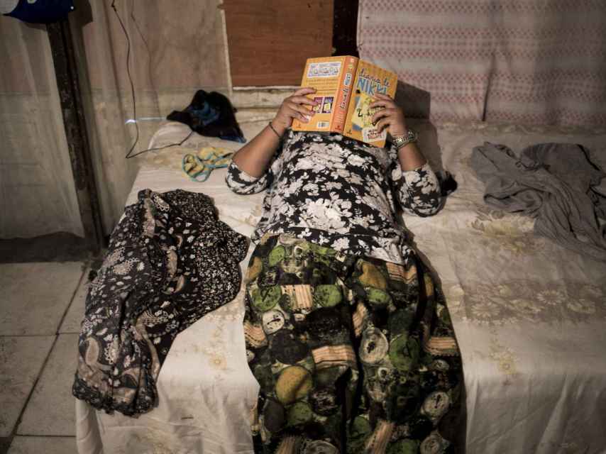 Valica, de 11 años, leyendo en su cama