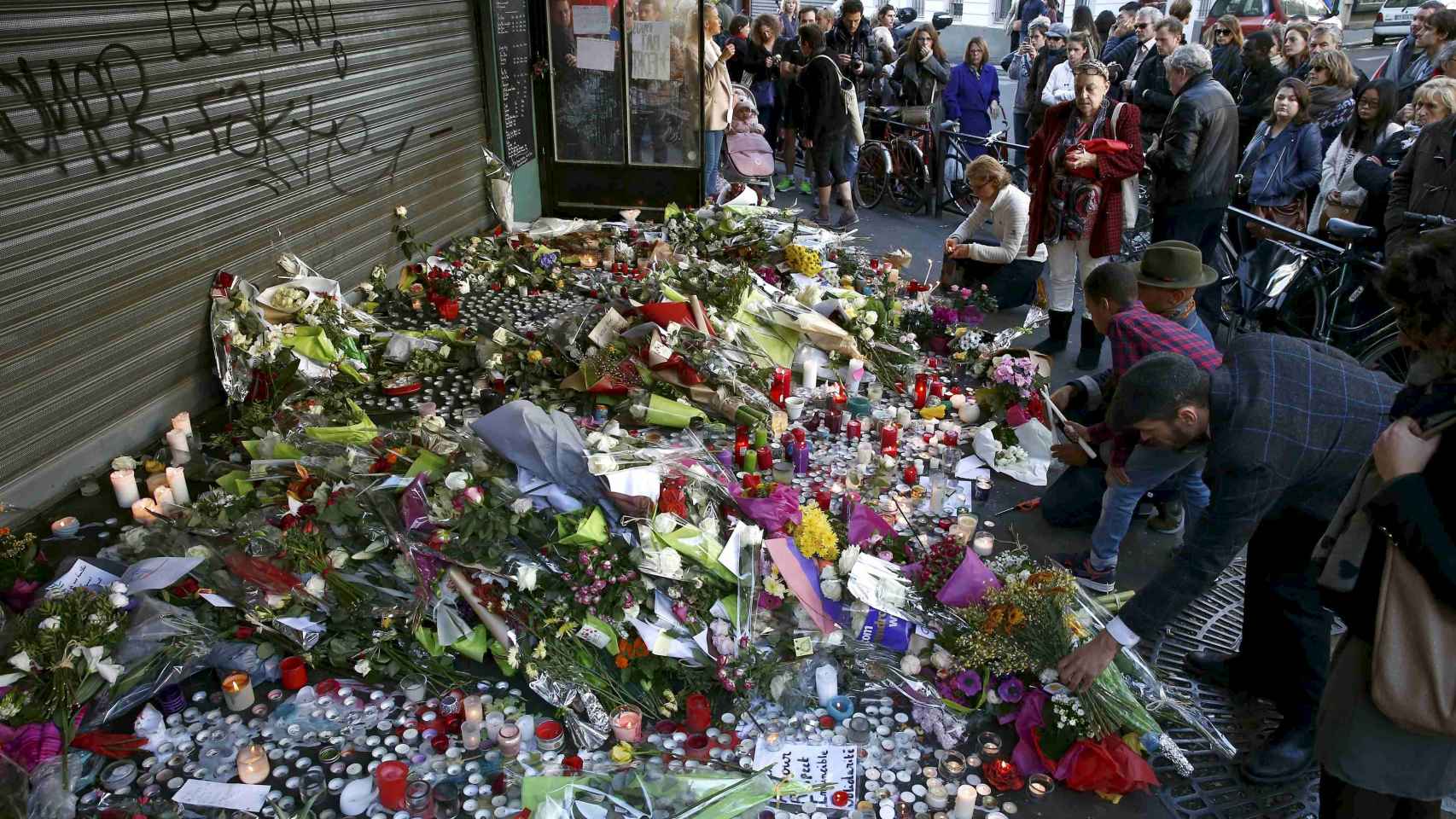 Varios ciudadanos muestran sus respetos en uno de los lugares de la tragedia en París.