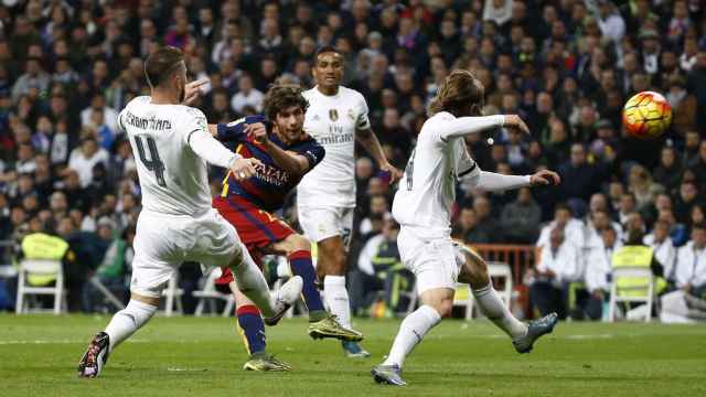 Sergi Roberto chuta a puerta entre varios jugadores del Madrid.