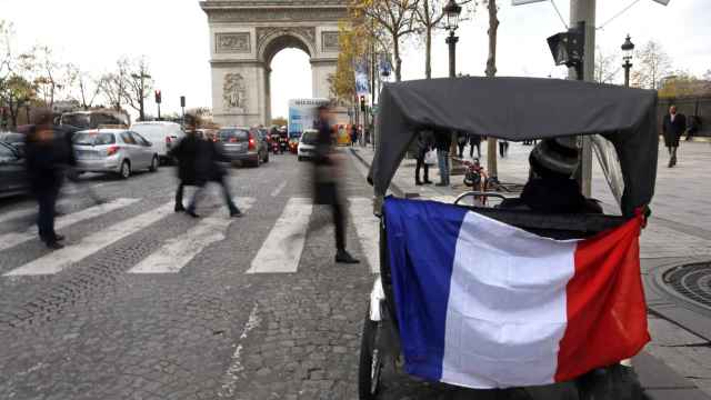 Un triciclo turístico ante el Arco del Triunfo de París se une al homenaje.