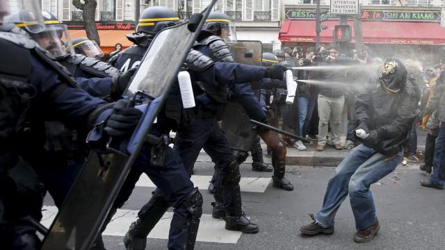 Policías antidisturbios se protegen con escudos en la Plaza de la República