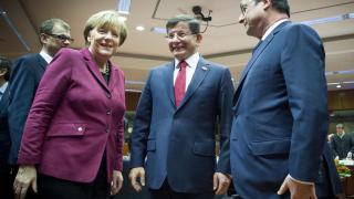 El primer ministro turco, Ahmed Davutoglu, con la canciller Angela Merkel y el presidente galo François Hollande