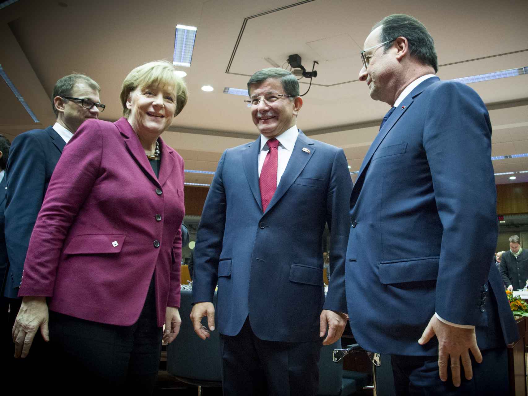 El primer ministro turco, Ahmed Davutoglu, con la canciller Angela Merkel y el presidente galo François Hollande