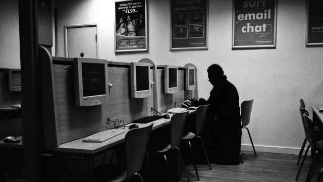 Un hombre consulta internet en un cibercafé.