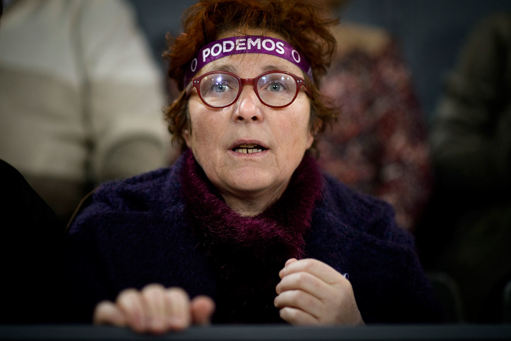 Una mujer sigue un discurso de Pablo Iglesias.