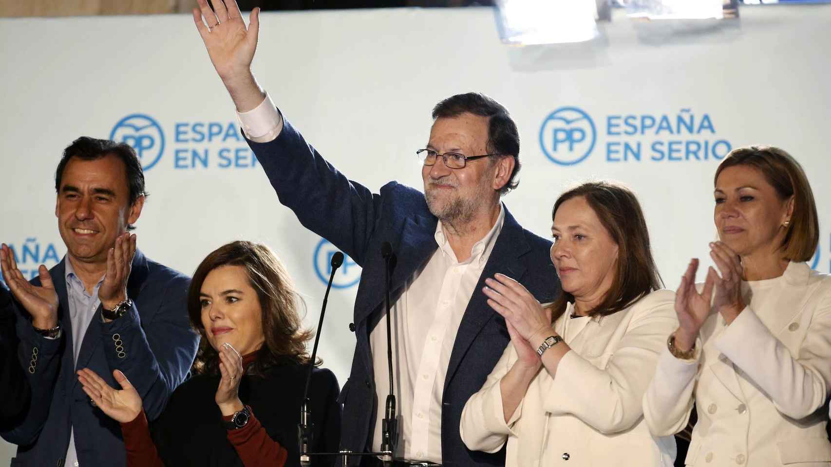 Rajoy sale al balcón de Génova acompañado por su equipo y junto a su mujer.