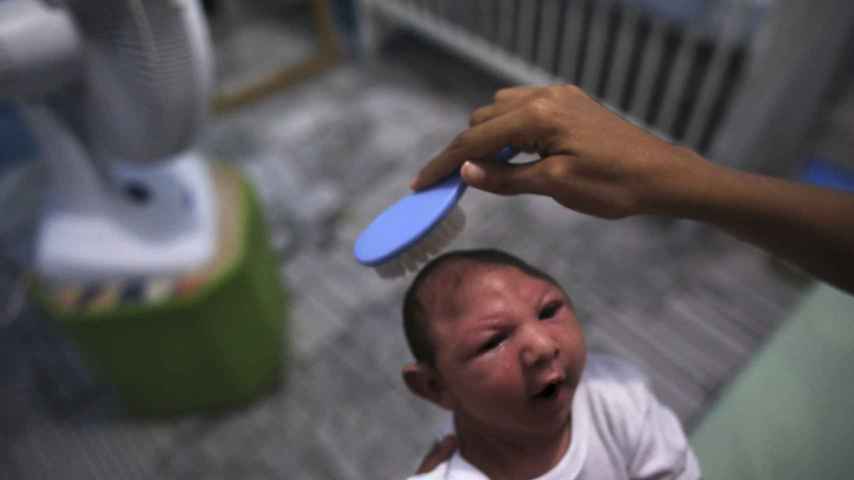 Daniele Santos peina a su hijo con microcefalia.