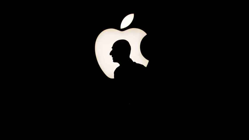 Un hombre pasa delante del logo de Apple