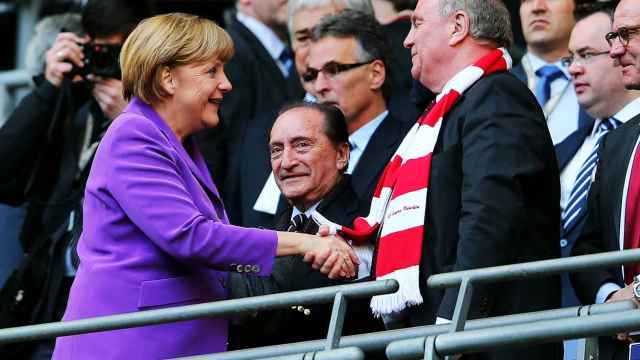 Uli Hoeness le da la mano a la Canciller Angela Merkel.