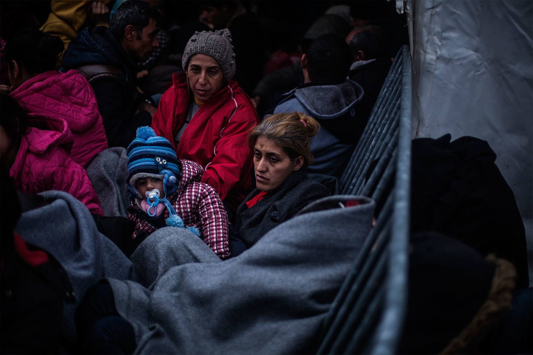 Una mujer espera con su bebé cerca del paso fronterizo de Idomeni.