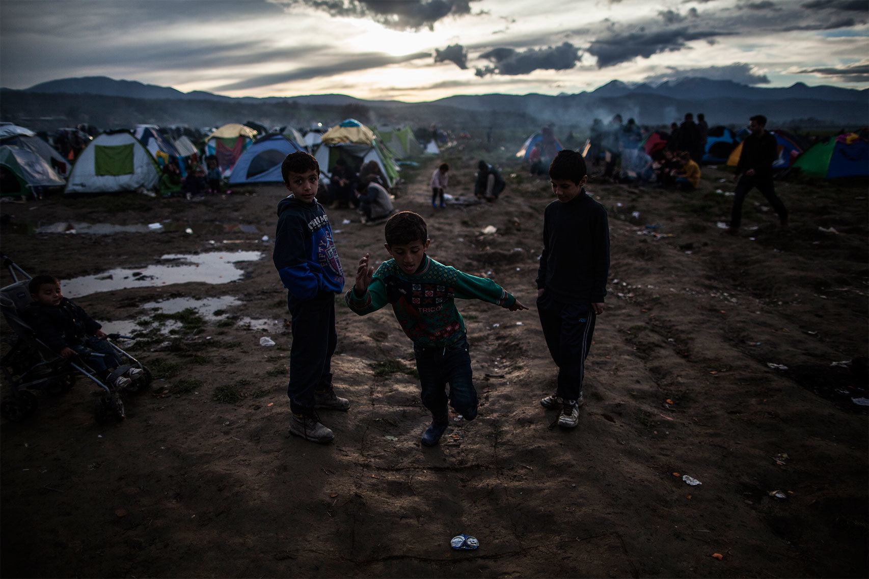 Niños juegan en medio del barro.