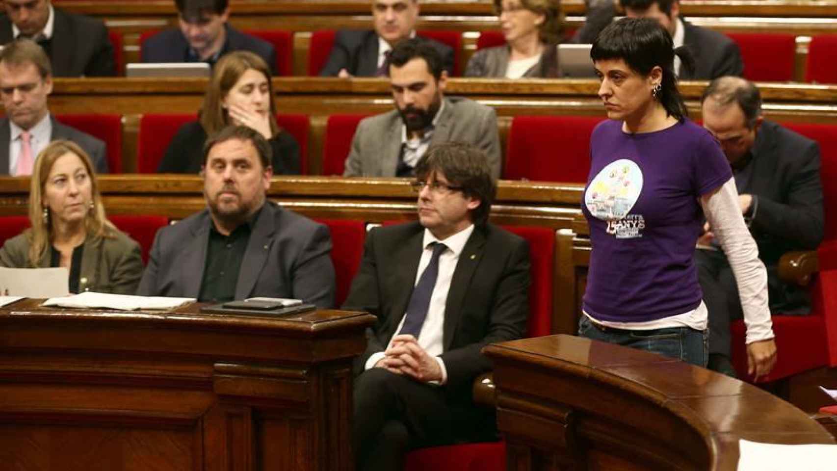 La diputada de la CUP, Anna Gabriel pasa ante el presidente de la Generalitat, Carles Puigdemont
