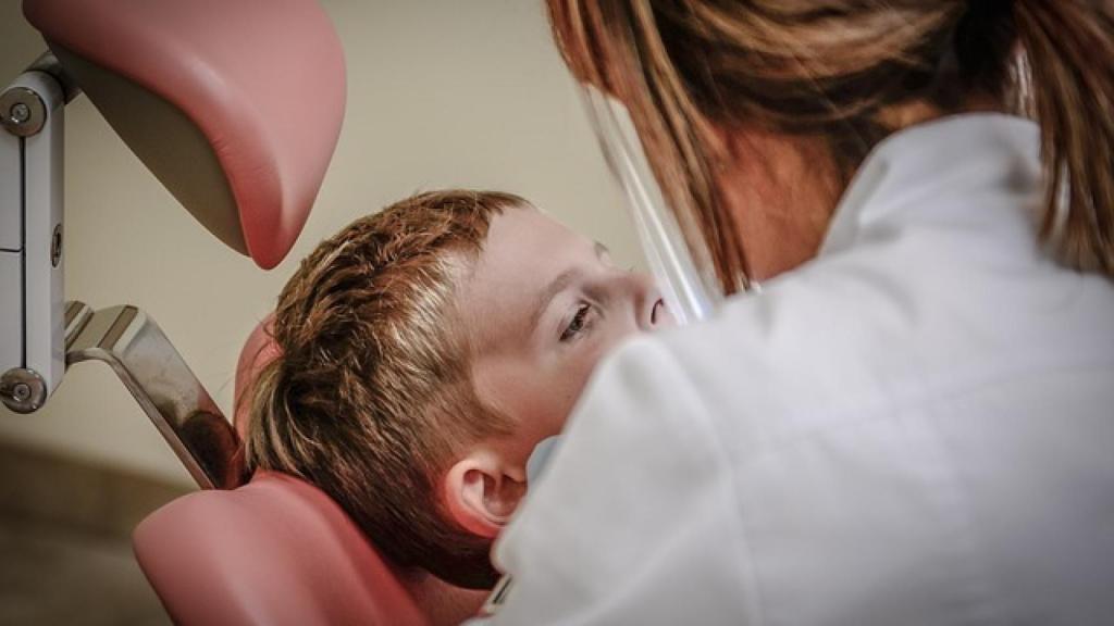 Un dentista atiende a una paciente.