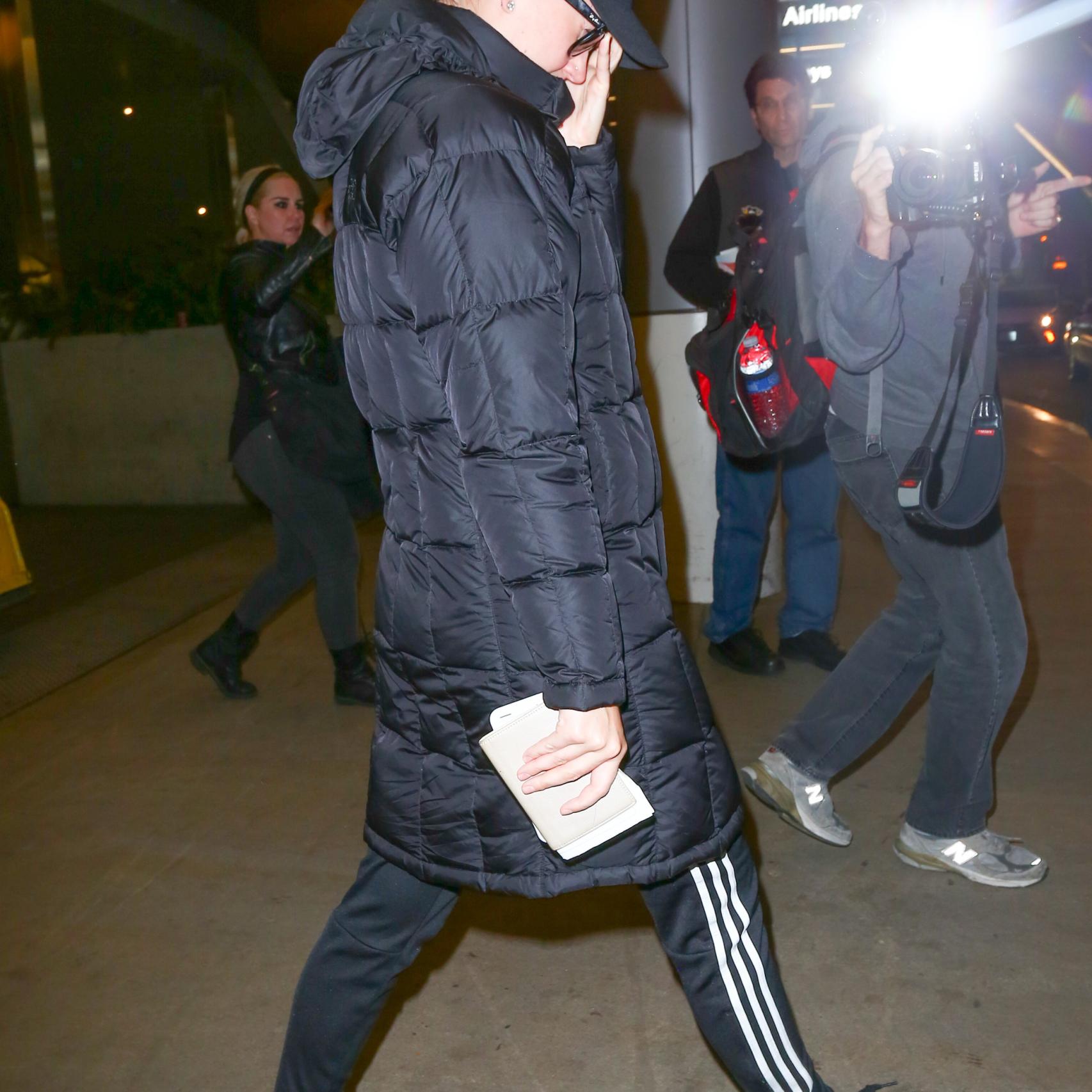 Katy Perry intenta ocultarse de los fotógrafos en el aeropuerto