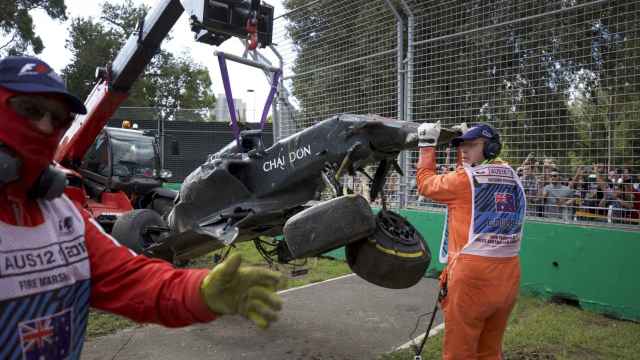 Los operarios retiran el coche de Alonso en Melbourne.