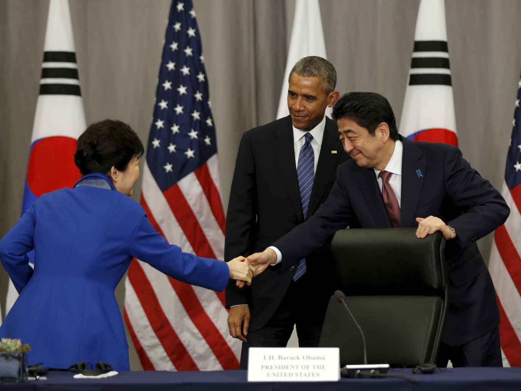 La mandataria surcoreana y el japonés se saludan en presencia de Obama.