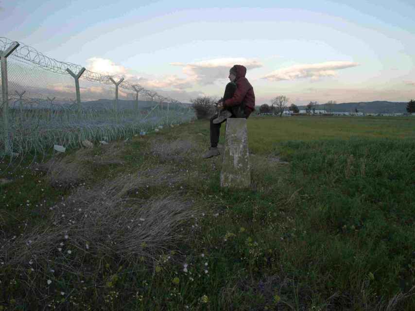 Un refugiado observa la alambrada de la frontera de Macedonia