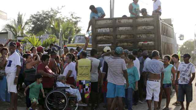 Personas reciben donaciones cerca del pueblo de Manta en Ecuador.