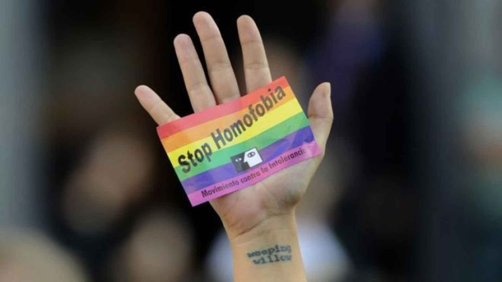 Un joven muestra una pegatina durante una concentración contra la homofobia en Madrid.