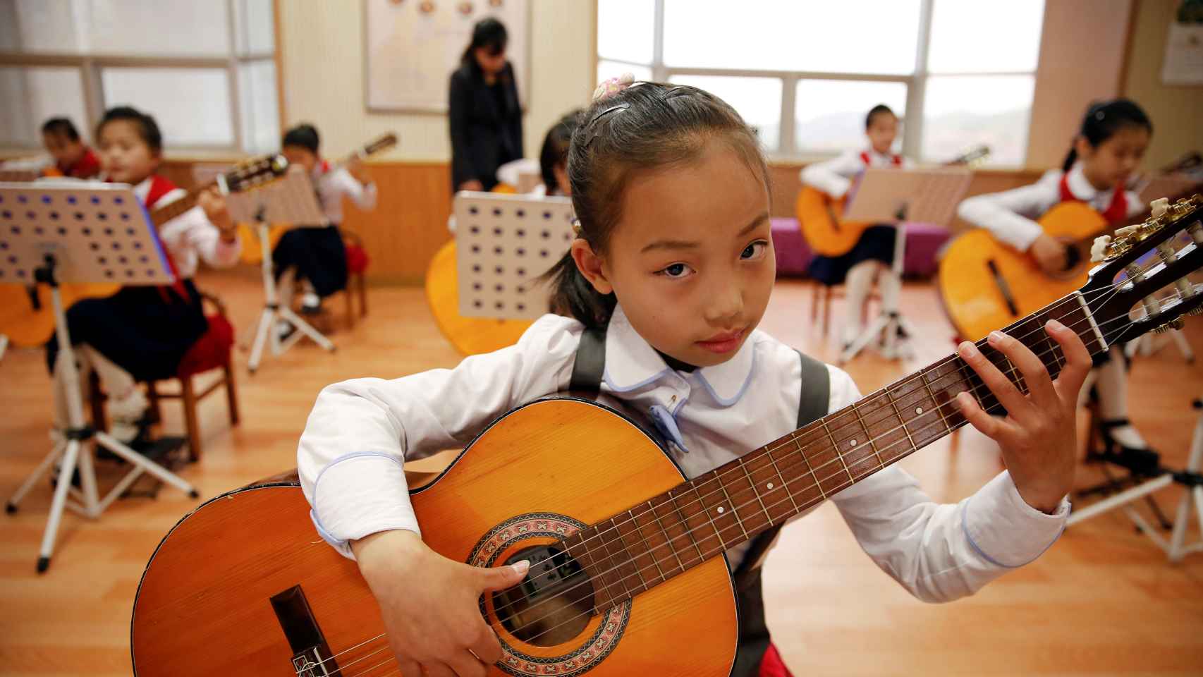Una niña toca la guitarra en el Palacio de los Niños Mangyongdae de la capital norcoreana en la víspera del séptimo congreso del Partido de los Trabajadores.