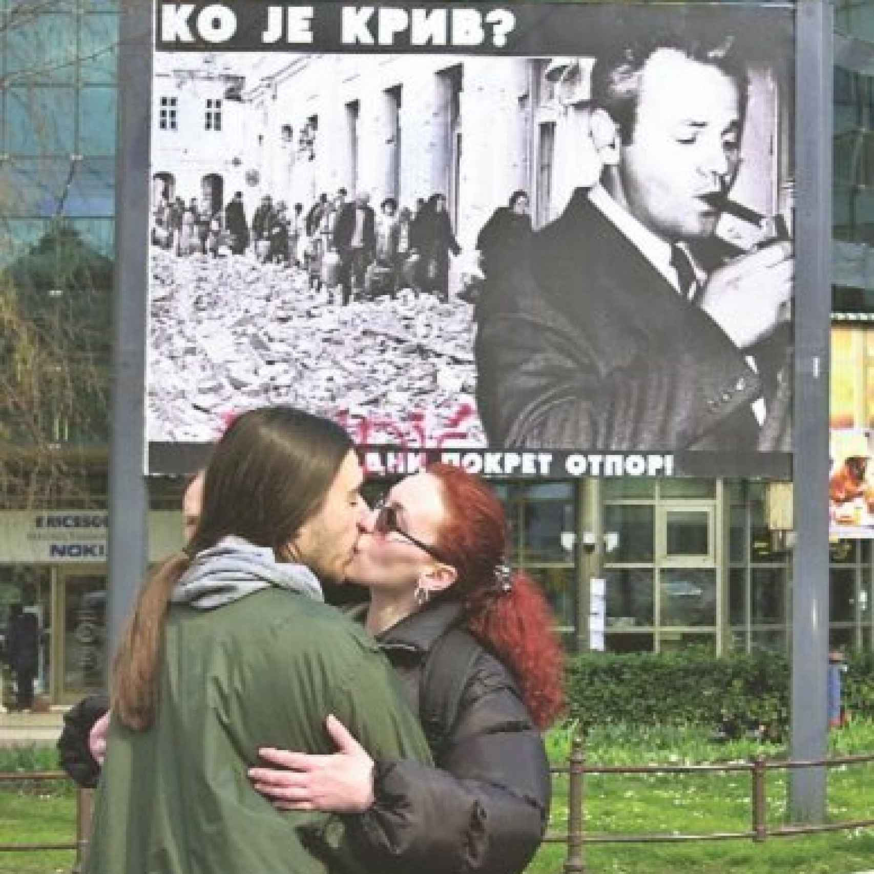 Una pareja se besa delante de la imagen de Slobodan Milosevic, en el año 2000.