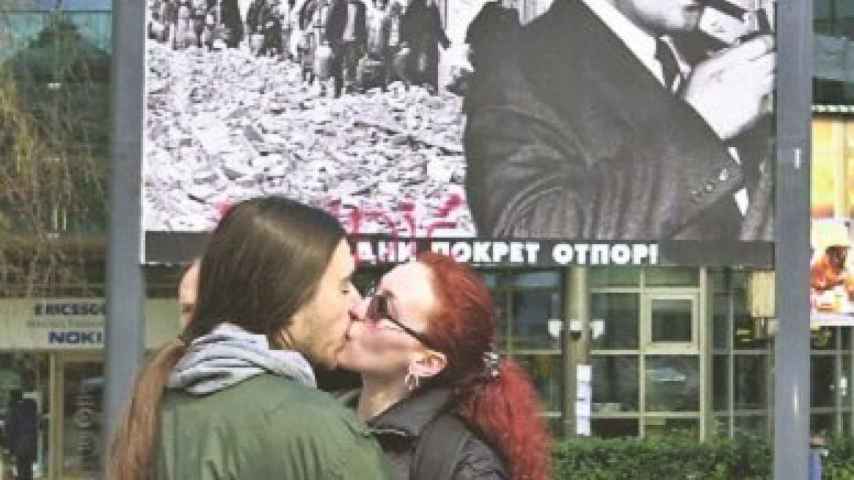 Una pareja se besa delante de la imagen de Slobodan Milosevic, en el año 2000.