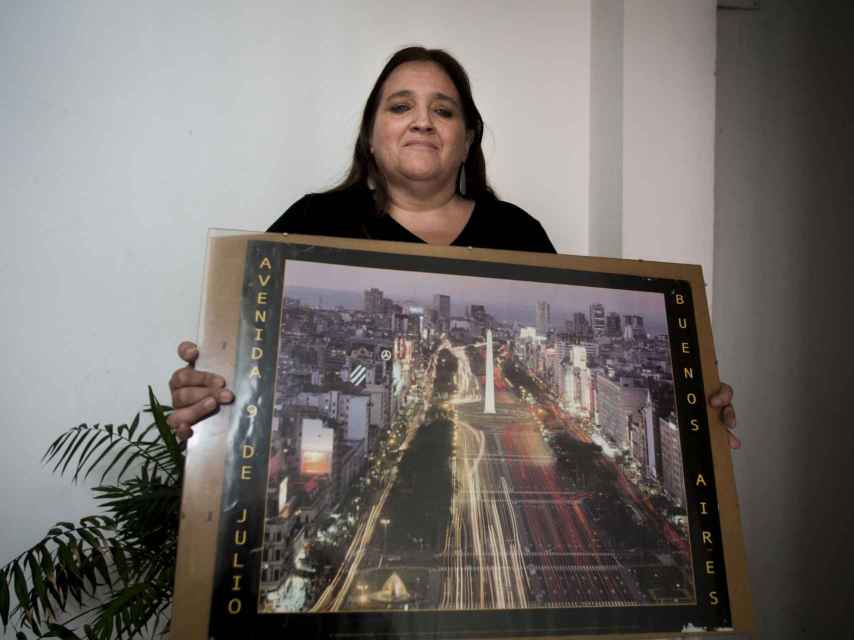 La periodista sostiene un cuadro con una imagen de Buenos Aires.