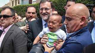 Un niño llora al hacerse una foto con Rajoy en Alfafar, Valencia.