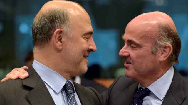 El comisario Moscovici conversa con el ministro Luis de Guindos durante un reciente Eurogrupo