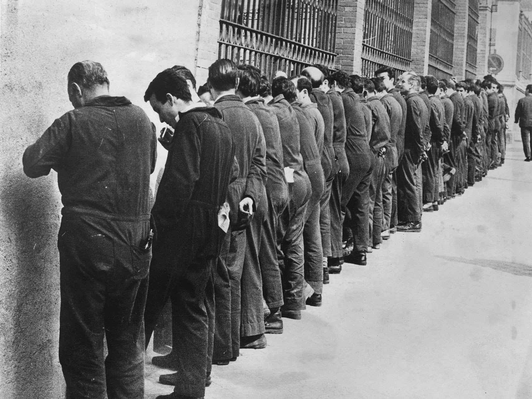 Obreros españoles protestan dedicando su pequeño tiempo de descanso a ponerse de cara a la pared de la fábrica.