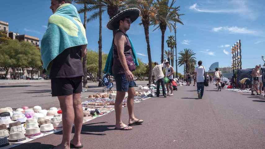 Centenares de turistas compran a diario productos falsificados en el paseo San Joan de Borbó