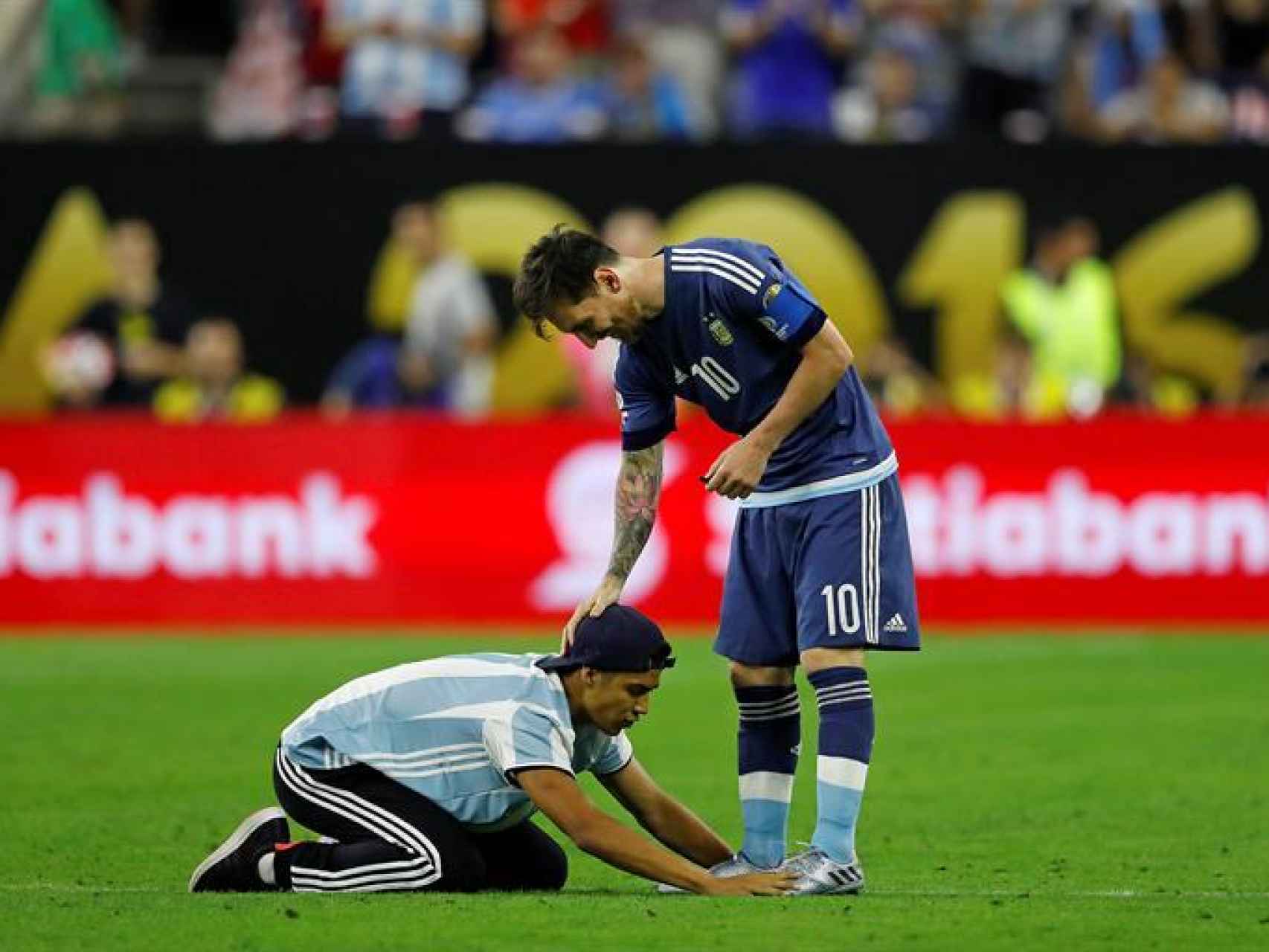 Un aficionado le besa las botas a Messi.