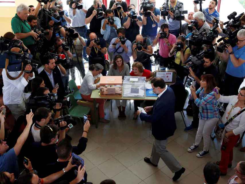 Rajoy deposita su voto en una de las urnas del colegio Bernadette de Aravaca, Madrid.