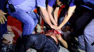 Los efectivos de emergencia tratan de ayudar a una persona herida durante la toma de rehenes en Daca.