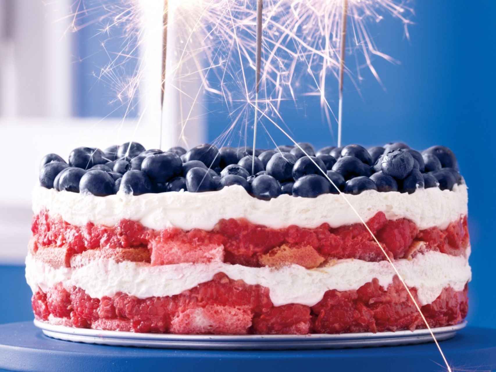 Suculenta tarta de arándanos, fresas y nata representando los colores de la bandera de EE.UU.