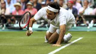 Federer cae tras pelear un punto en su partido ante Raonic.