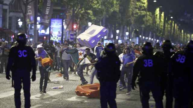 Aficionados franceses se enfrentan a los policías en los Campos Elíseos.