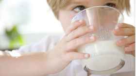Un niño pequeño tomándose la leche.