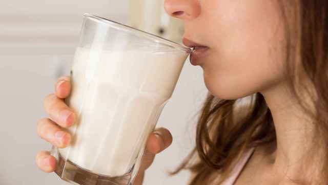 Una joven bebe un vaso de leche