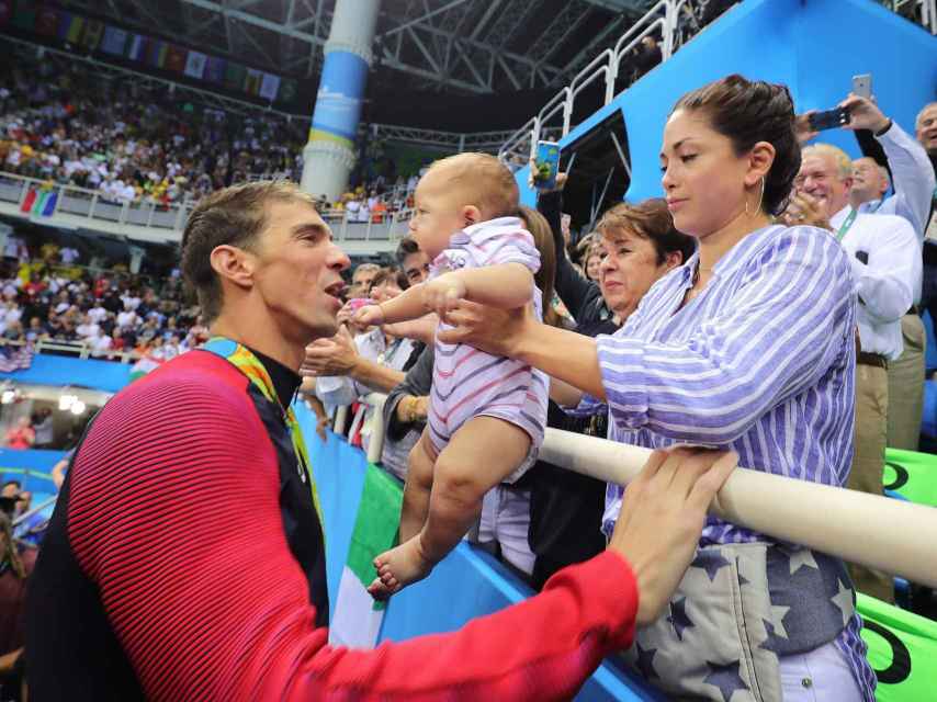 Michael Phelps celebra su victoria con su hijo Boomer y su pareja Nicole.